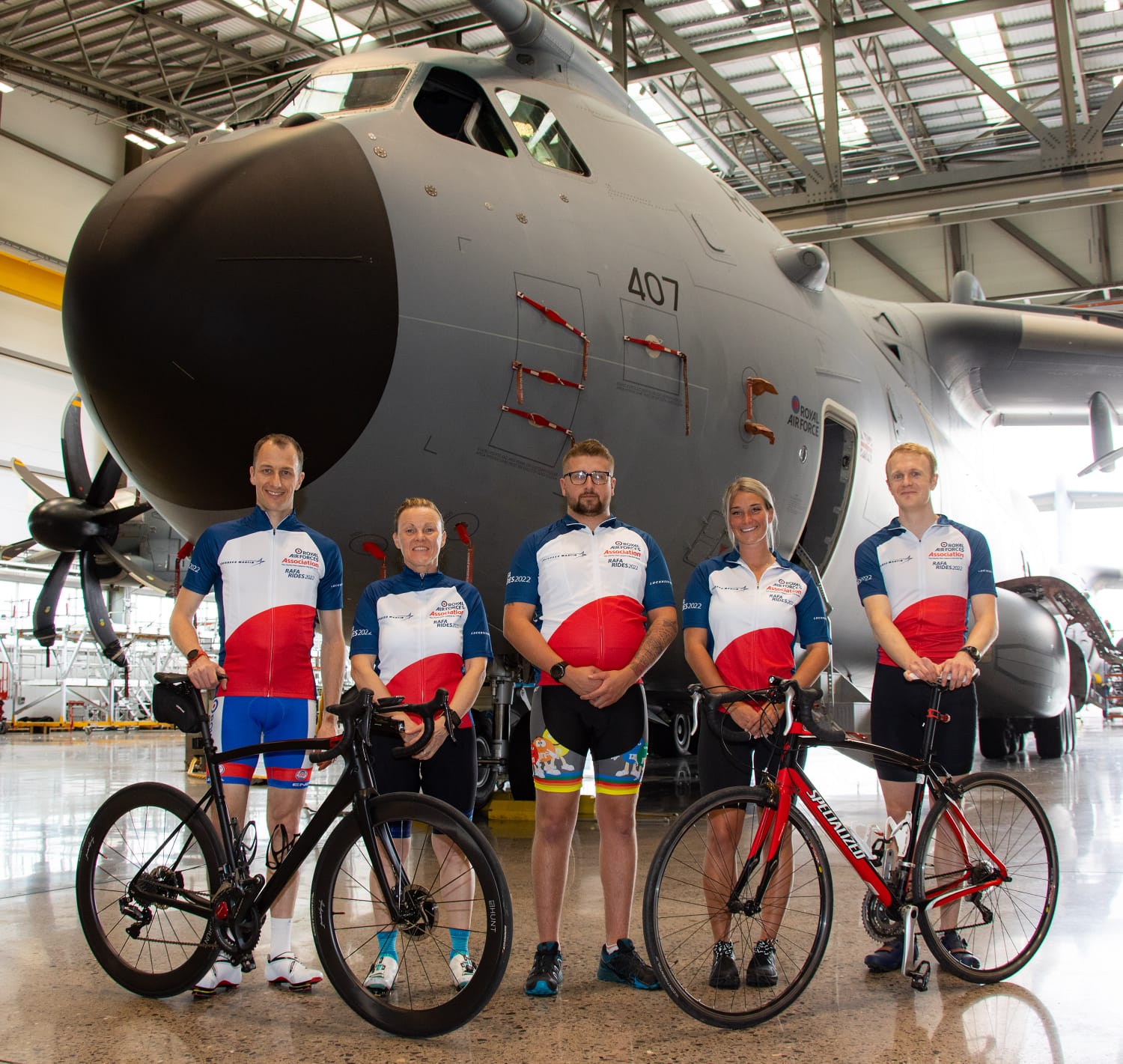 RAF Association members stand with bikes before Atlas aircraft.